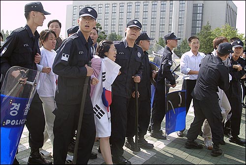 국회의사당앞에서 태극기를 몸에 두르고 시위를 벌이던 대학생 3명이 경찰에 연행되고 있다. 